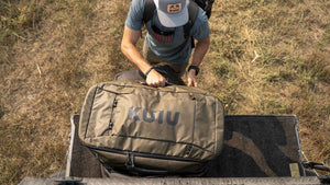 Aerial View of Hunter Loading Waypoint 5500 Duffel in Bourbon Brown Color into Truck Bed
