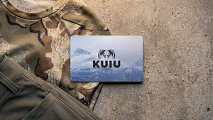 KUIU gift card on a Valo Camouflage base layer top and pants with a concrete background.