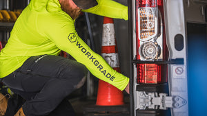 Man kneeling in an indoor utility room, appear to be reaching for something, wearing Workgrade Long Sleeve Sun Hoodie in neon yellow‑green Highlight color