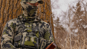 Turkey hunter sitting against a tree while wearing a Gila Long Sleeve Hoodie in Verde camouflage.