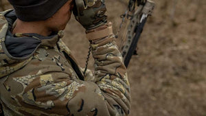 Slight close-up of the side of a male hunting for Whitetail Deer in a tree stand in head to toe KUIU.