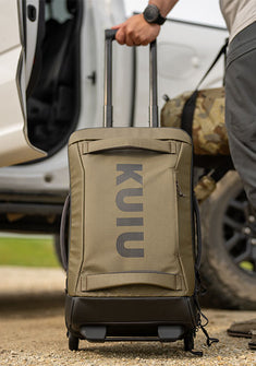 Close-up of Waypoint 3000 Carry-On Roller in Bourbon Brown being pulled across a gravel surface