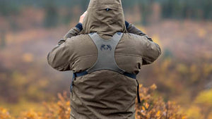 Male hunter with his back turned and with an Ash KUIU PRO BIno Harness glassing.