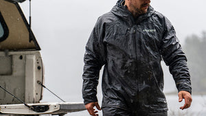 Male outside in rain and fog loading his truck bed in Northridge Rain Gear in Gunmetal.