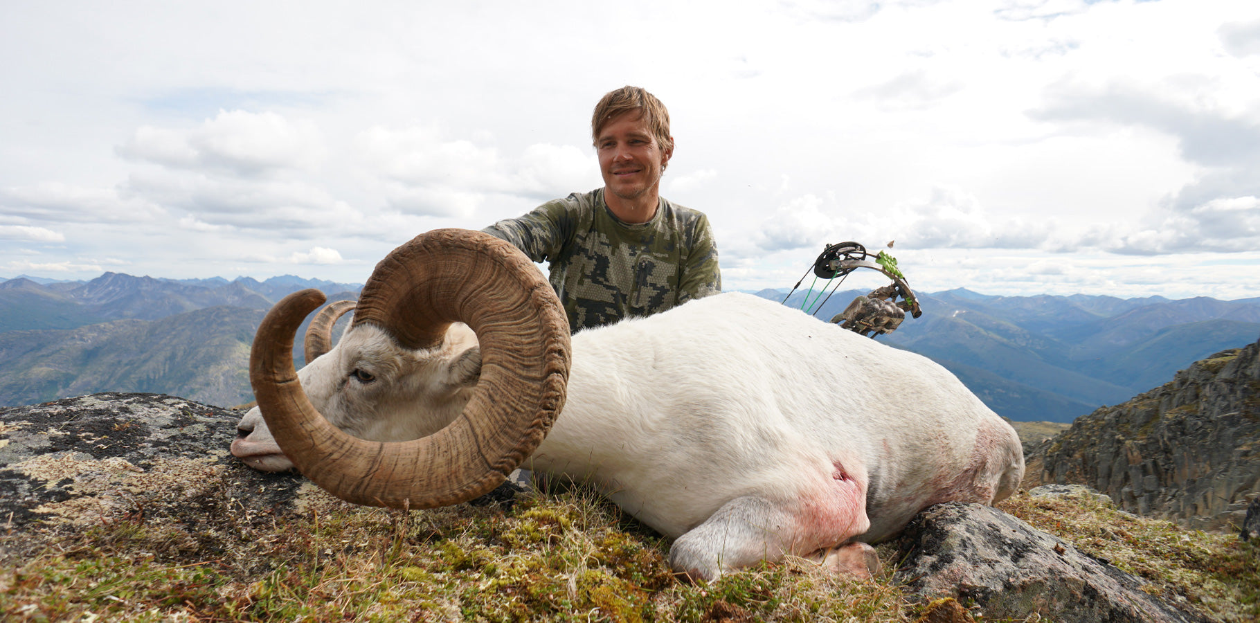 Allen Bolen in Verde camouflage with his record book stone sheep harvested with his bow in the Yukon