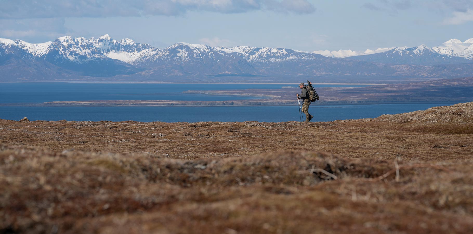 A hunter backpacking across the tundra.