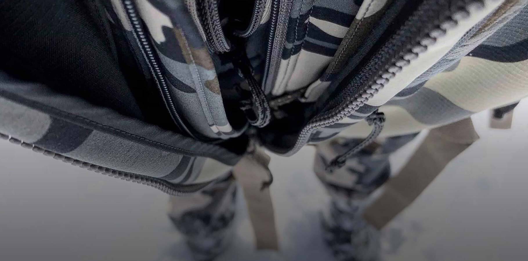 Close up detailed view looking down at the chest of hunter wearing multiple zippered layers to show the multiple layers being worn over each other
