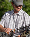 Hunter adjusting arrows on his bow wearing Borrego SS Shirt in Grey Granite Plaid