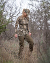 Woman hunter walking through brush wearing Women's PRO Brush Pant in Valo Camouflage