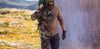 Stylized image of a man showing half his body wearing KUIU Vias Camouflage, including the Attack Pant, and the other half of his body wearing solid KUIU workwear, including the Attack Pant in Gunmetal.