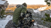 Angled, Back View of Hunter in Verde Camouflage Watching Deer Through Spotting Scope