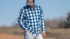 Hunter looking down with right hand in his pocket, wearing Borrego LS Shirt in Blue Lake Plaid
