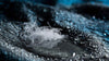 Close-up view of a cluster of goose down feathers on a dark fabric with water droplets