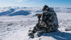 Back of Hunter Glassing Game in Snow Covered Terrain Wearing Kutana Gale Force Hooded Jacket and Pants in Vias Camouflage