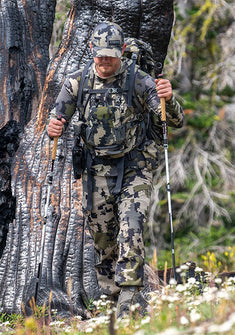 Backpacking hunter appears focused, trekking through the woods