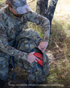 Angled, Front View of Hunter Putting Small Zip Dry Bag into External YKK Zippered Storage Pocket