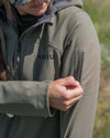 Hunter unzipping the bicep zipper of the Women's Guide DCS Jacket in Ash Brown